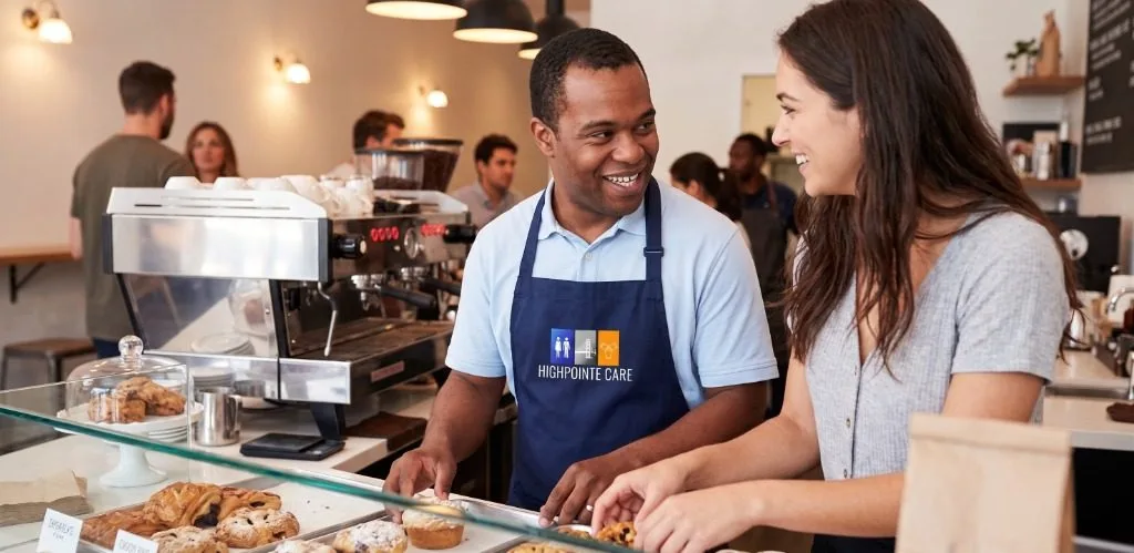 Supported employee working at bakery counter in community business
